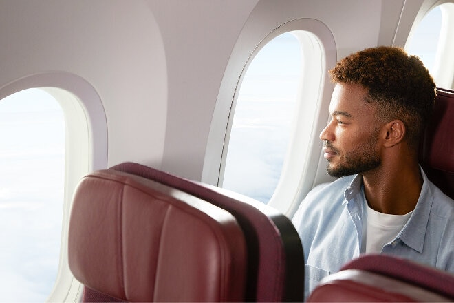 man looking out window in economy