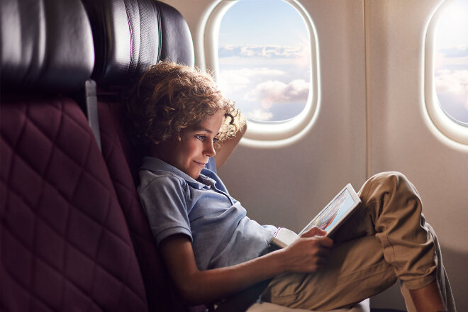 A boy sitting in an A330 economy window seat