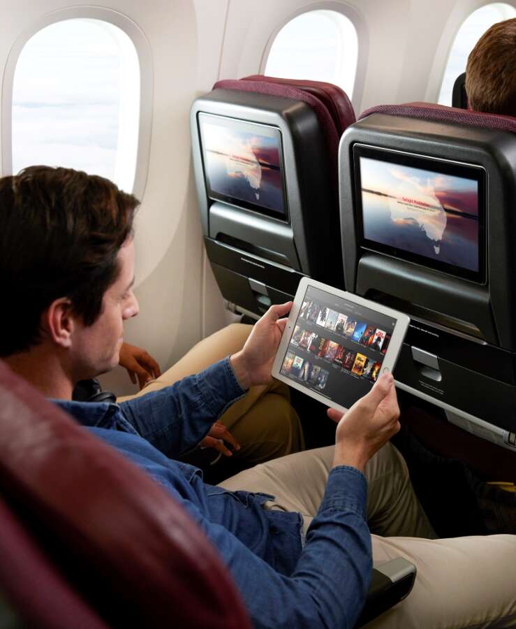 Man browsing Qantas app in B787 Premium Economy