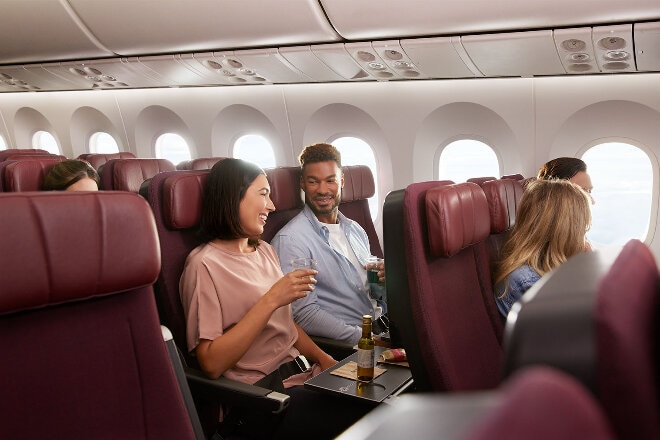 A couple sitting in the Economy cabin enjoying the inflight beverage service