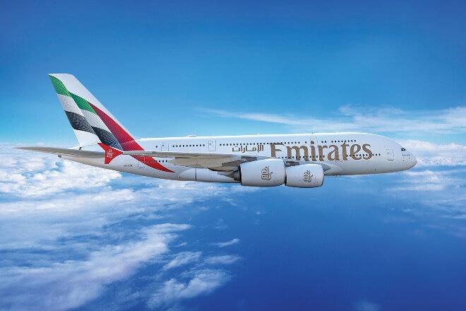 Emirates aircraft flying above the clouds