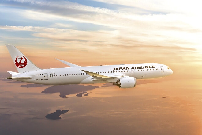 Japan Airlines aircraft flying above clouds