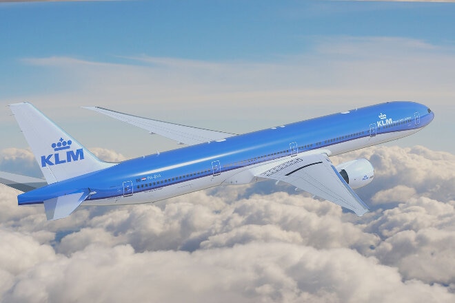 KLM aircraft flying above fluffy white clouds