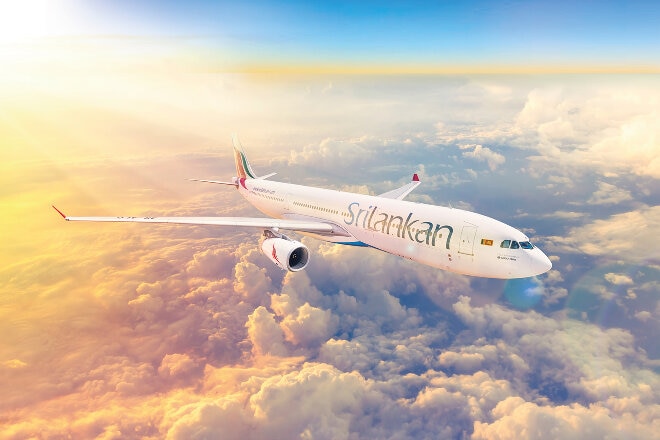 SriLankan Airlines flying over clouds at sunrise