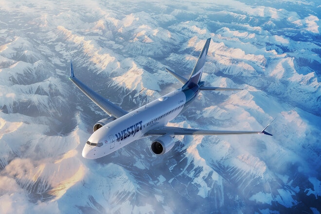 WestJet aircraft flying over snow-capped mountains