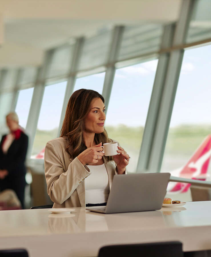 Lady sitting in Qantas Club using her laptop