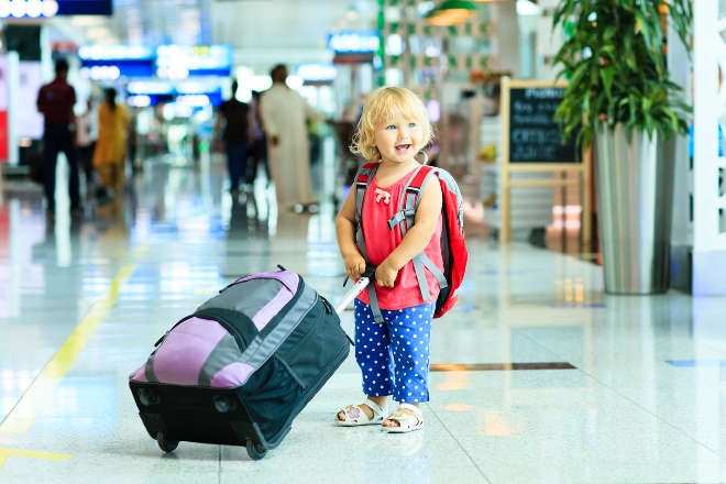 child at airport with luggage