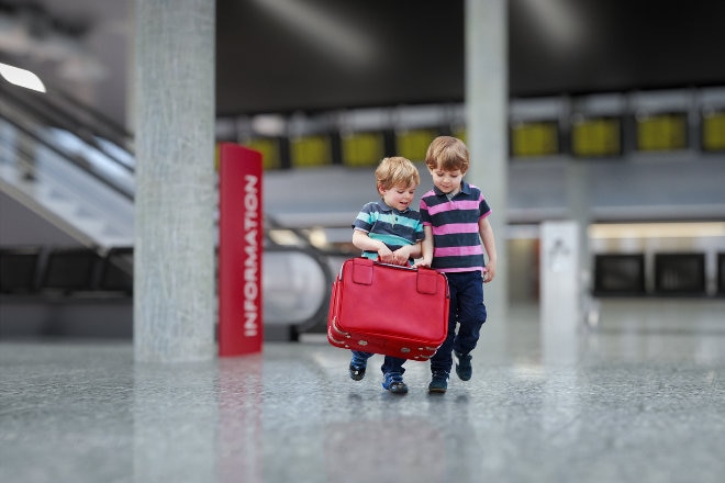 Children crrying luggage through the airport