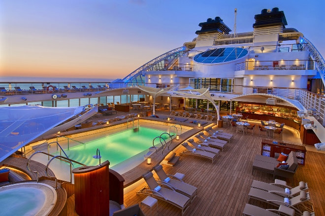 Seaborn Encore luxury ship deck at sunset with pool 