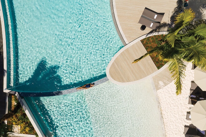 Woman lying in pool at the Crystalbrook Riley, Cairns