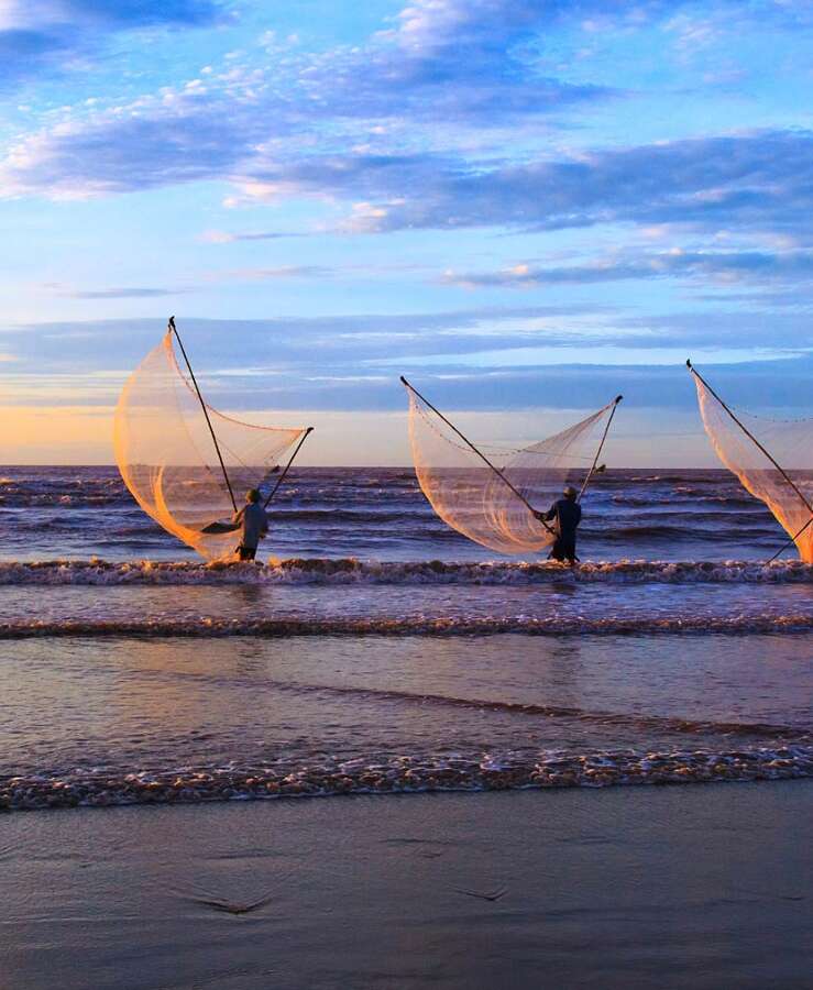 Fishermen using fishing gear in ocean in Nam Dinh, Vietnam