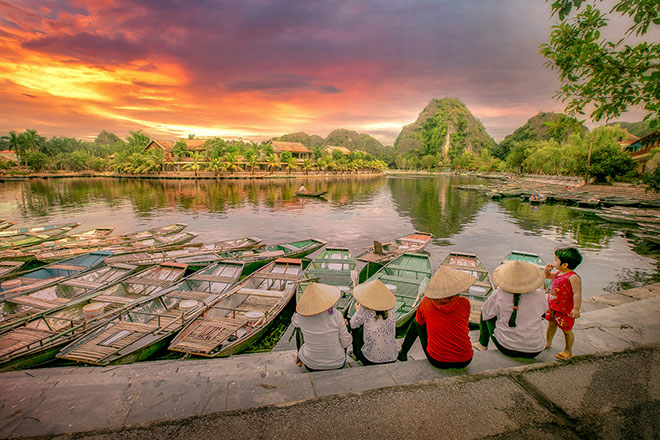 vietnamese family on banks of Mekong river with boats