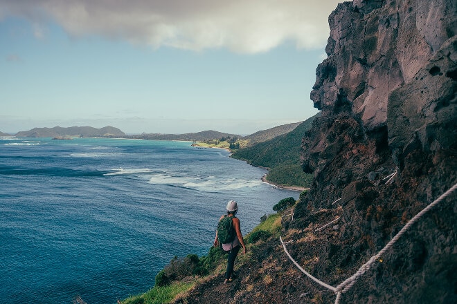 Lady hiking on Lord howe island green hills and water