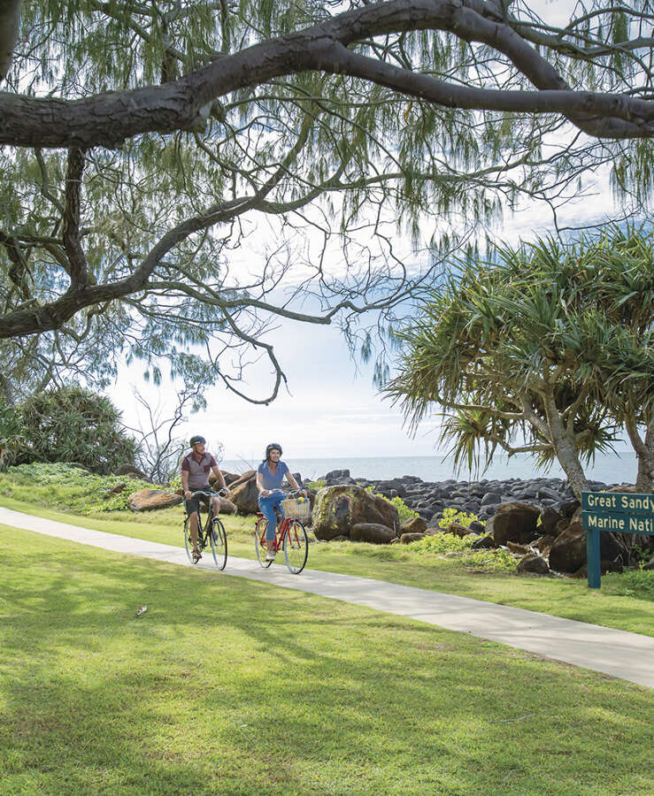 Couple riding bikes along boardwalk