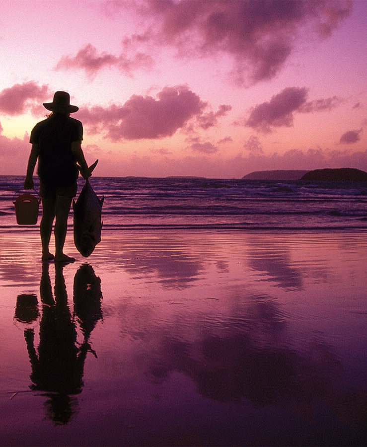 Fisherman on beach at dusk