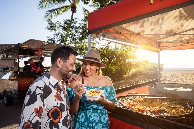 Couple tasting food at sunset market