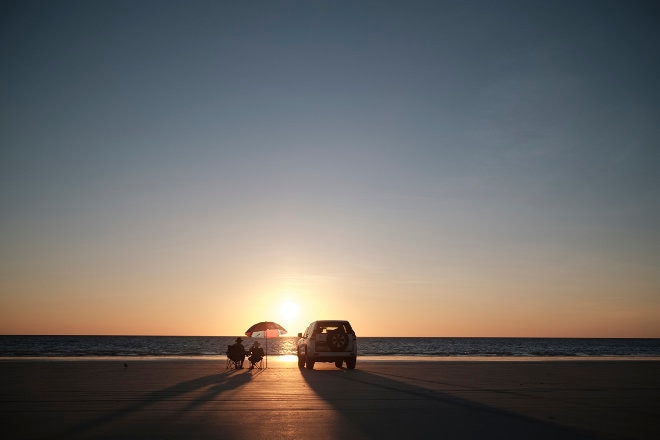 Car on the road at sunset near Cable Beach Broome