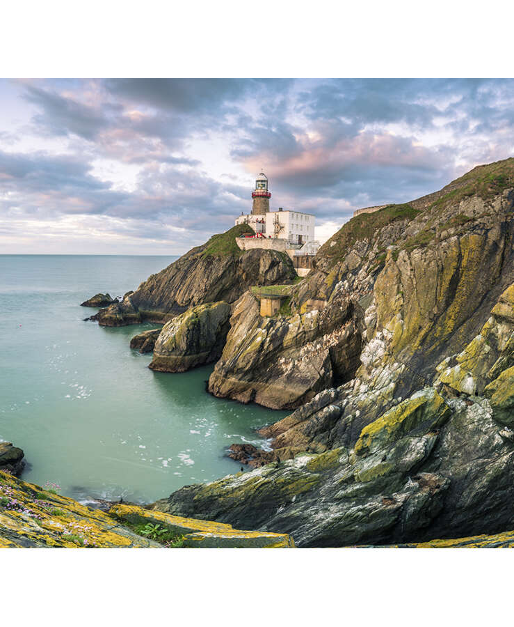 Baily lighthouse, Howth, County Dublin, Ireland, Europe. Panoramic view of the cliff and the lighthouse at sunrise.