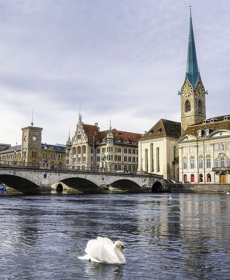 Bridge Over River By Buildings Against Sky