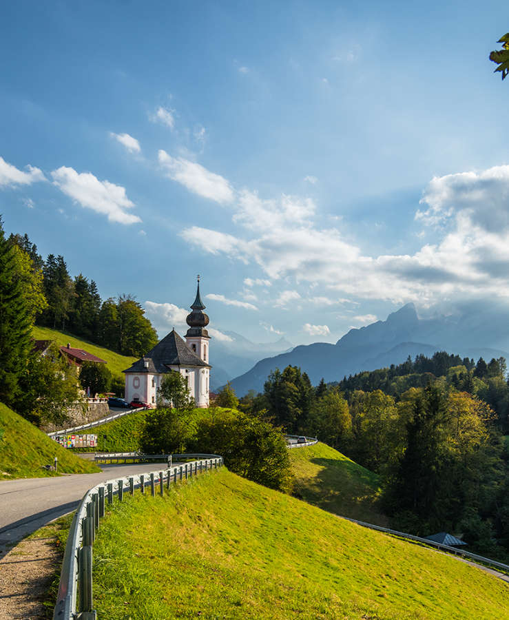 Lady riding bike through green hills and blue sky