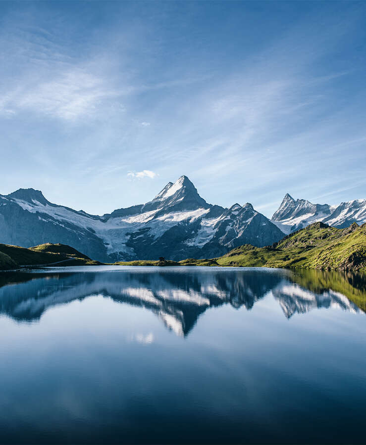 Scenic View Of Lake And Mountains Against Blue Sky