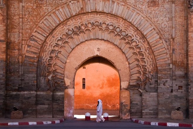 Woman in traditional arab clothing out the fron of building in sunlight