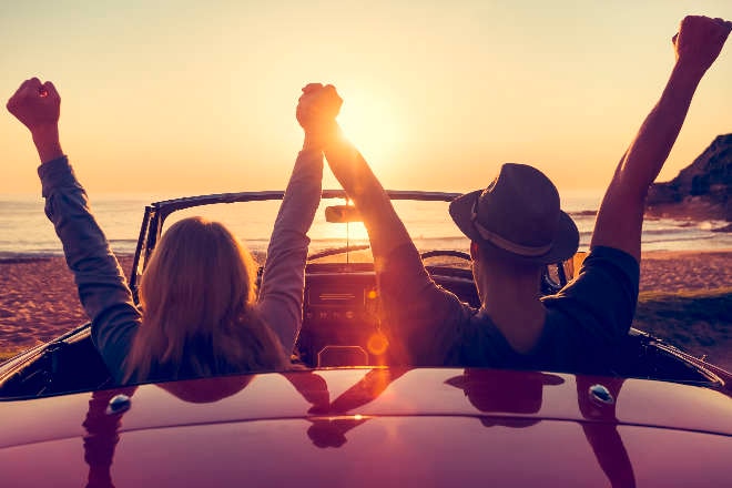 Couple in a convertiable car at sunset