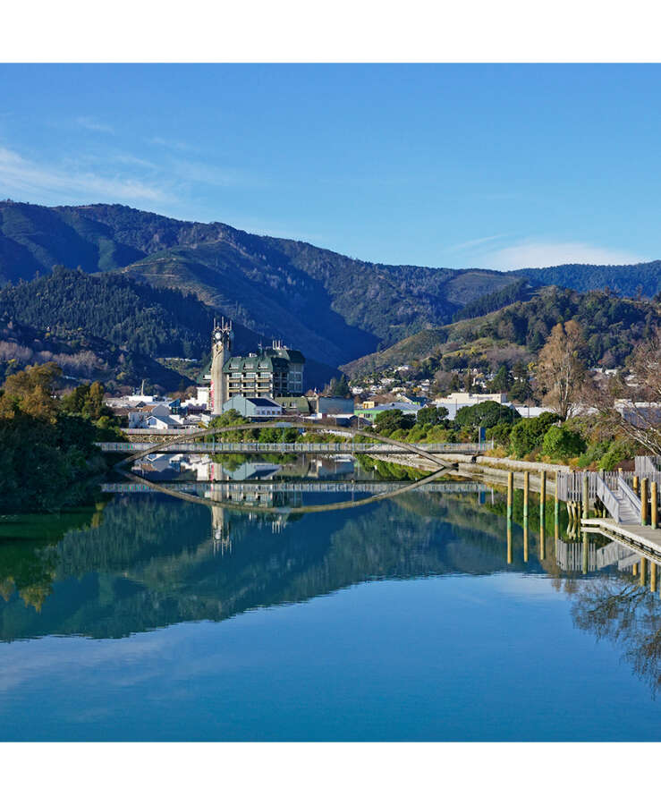 Nelson City, reflected in the Maitai River, New Zealand.