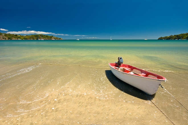 Red boat in grass overlooking bay