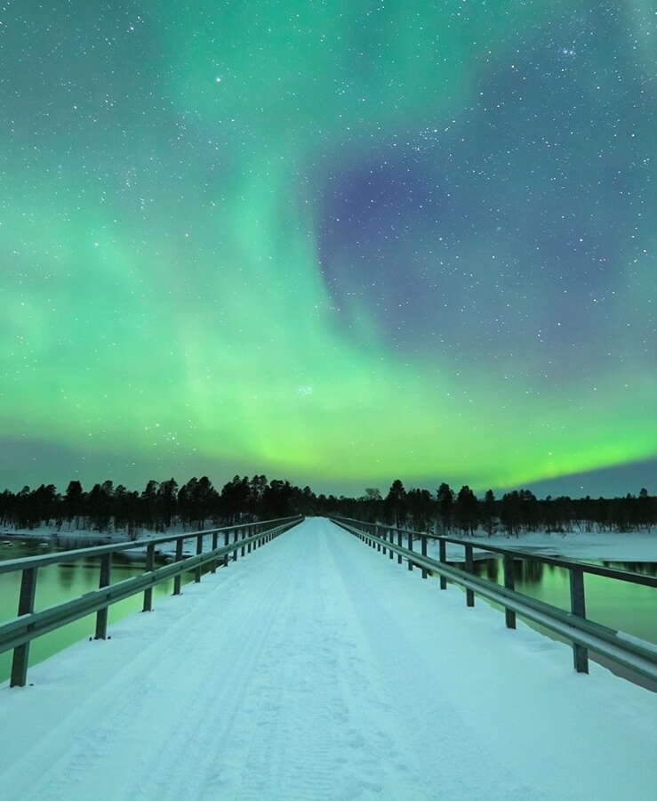 Aurora borealis over a bridge in winter, Finnish Lapland