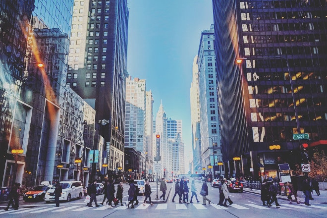 People walking across crossing in between buildings