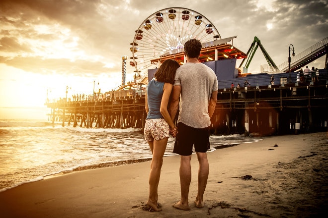 Couple walking on the beach at St Monica pier, Los Angeles