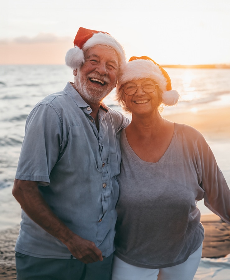 Couple on beach with Christmas hats