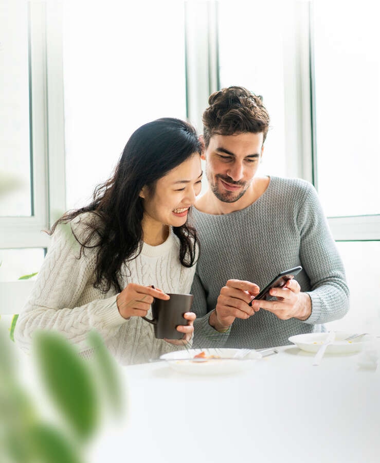 Couple sitting at the table looking at mobile