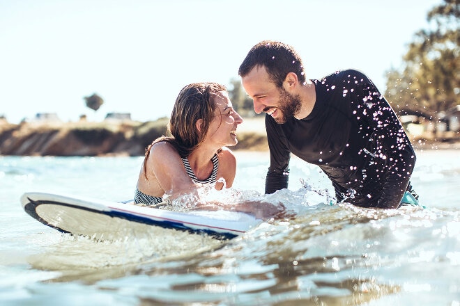 Couple surfing in water