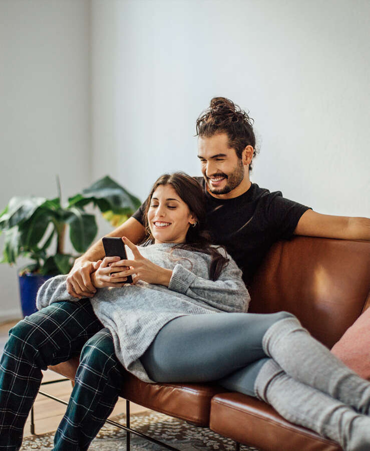 couple on lounge looking at mobile