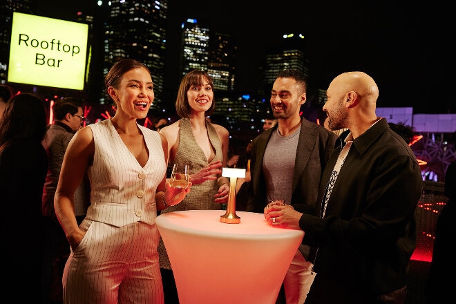 Friends gathering at the Rooftop Bar in Melbourne at night