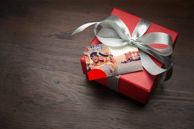 A gift wrapped in red paper with white bow