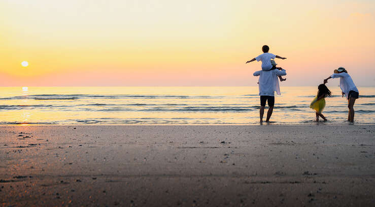 Family on beach at sunset