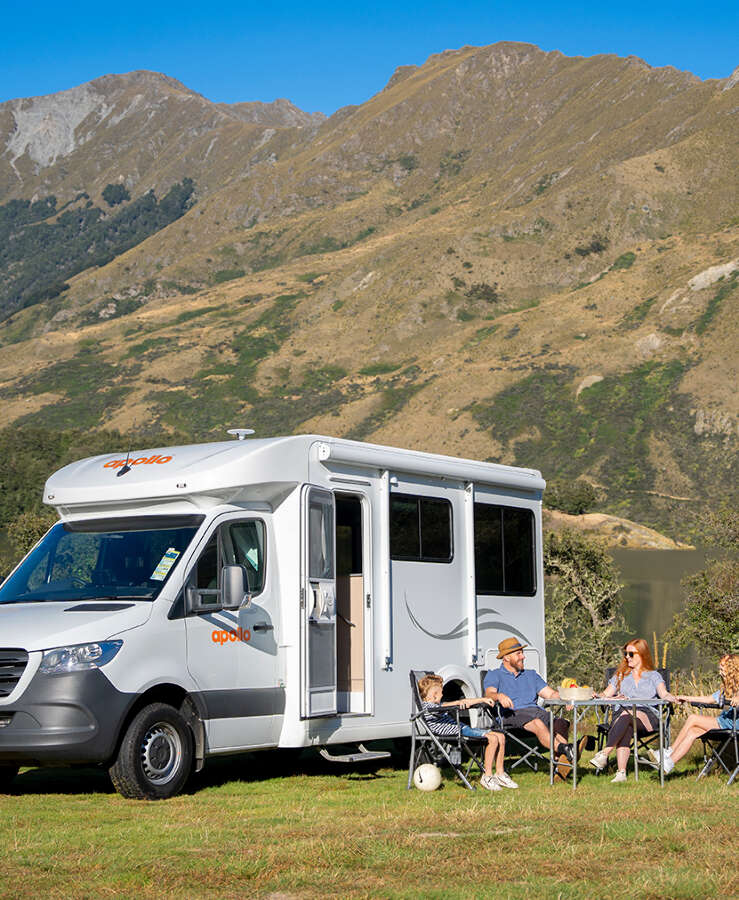 Family enjoying a countryside rest stop by their Apollo motorhome