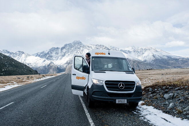 apollo white van on road snowy mountains