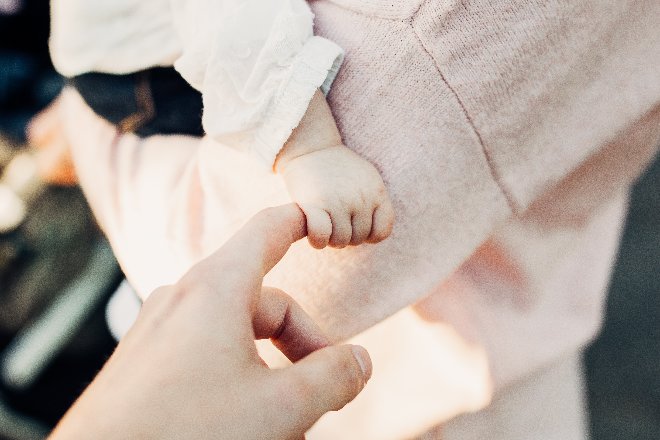 Baby clutching parent's hand