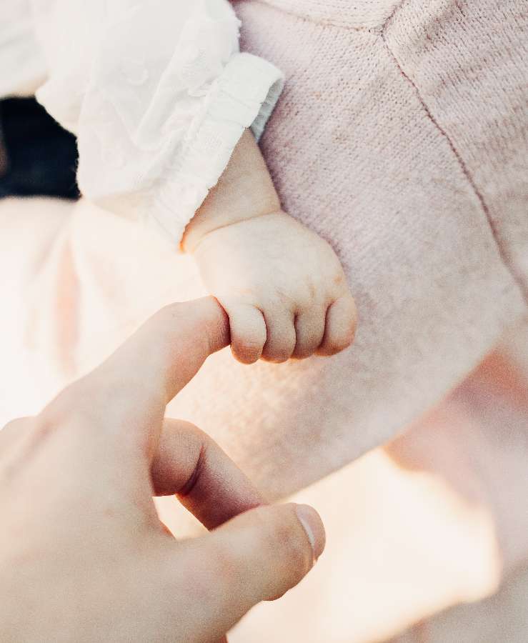 Baby fist holding parents hand