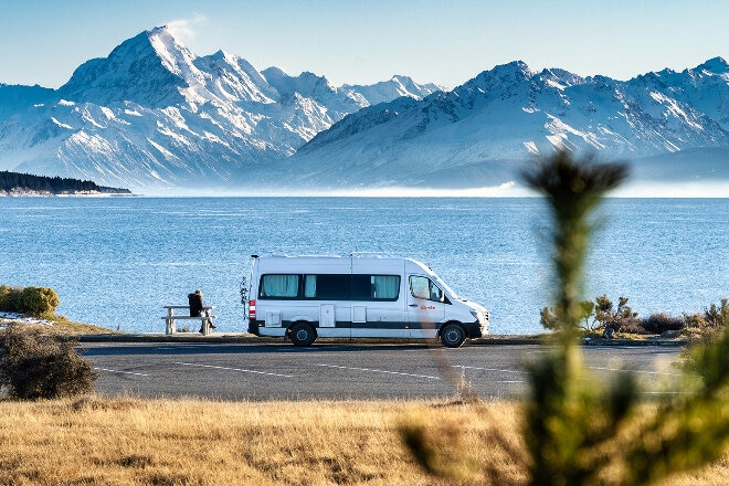 Britz campervan parked on the side of an alpine lake