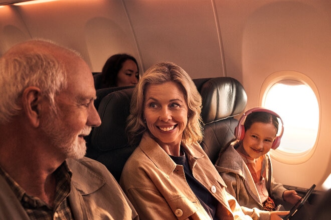 Family onboard a flight looking forward to their holiday