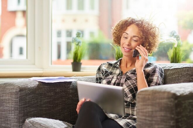 Woman on phone with laptop