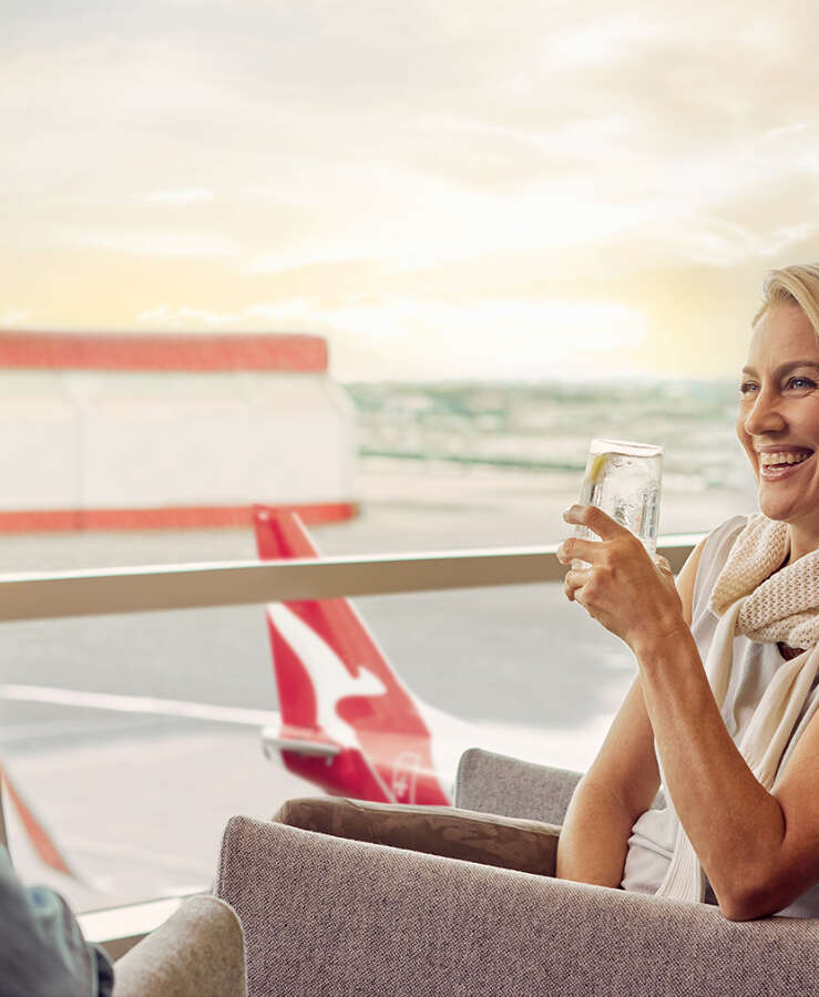 Female enjoying a drink in the Qantas Lounge