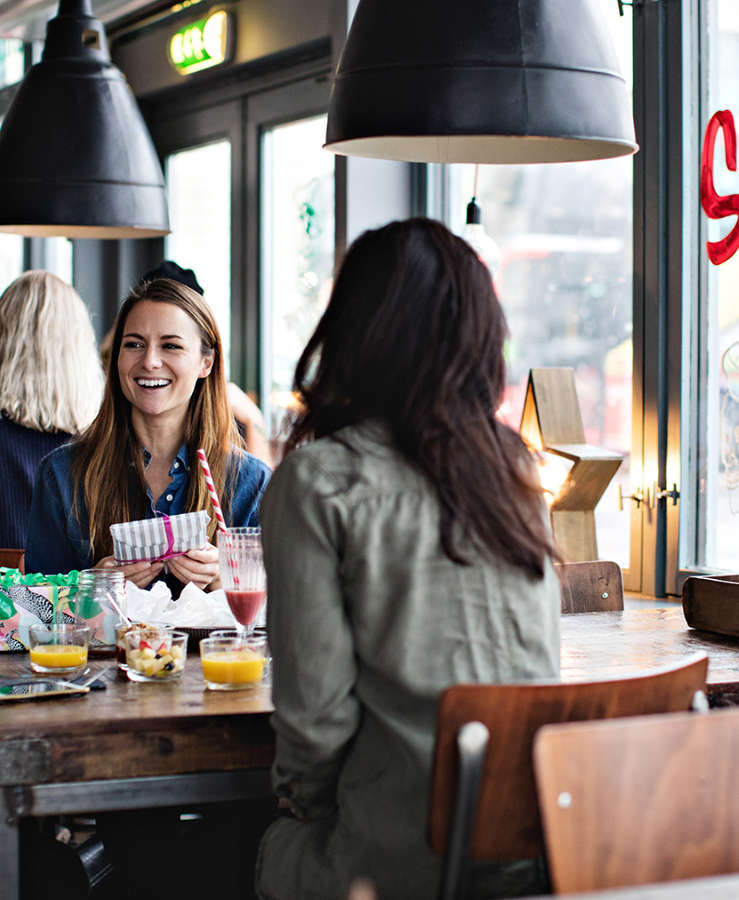 Female friends smiling at a cafe