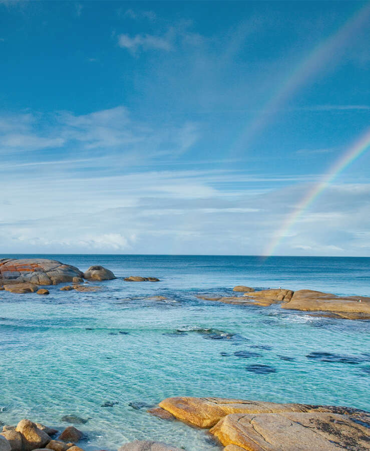 Rainbow over clear rocky water