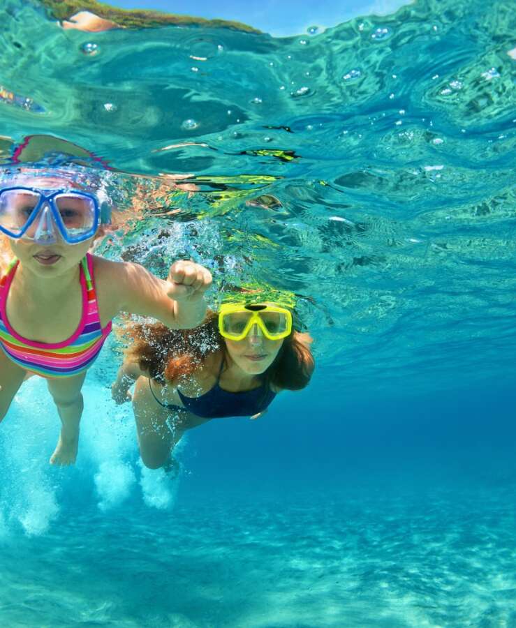 Woman and daughter snorkelling in the ocean